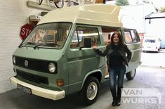 a woman standing next to a green van