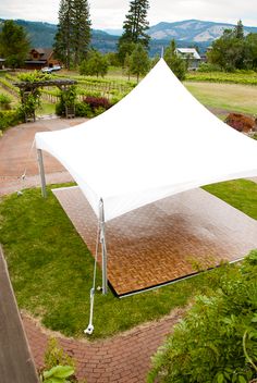 a white tent sitting on top of a lush green field