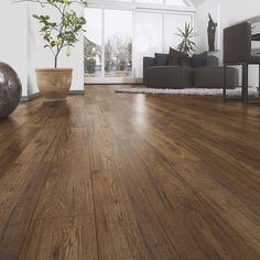 a living room filled with furniture and a wooden floor covered in hard wood planks