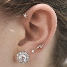 a close up of a person's ear with three different piercings on it