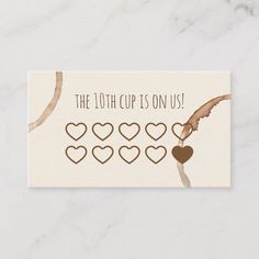 the 10th cup is on us card with hearts and an arrow in brown, beige and white