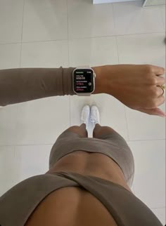 a person with an apple watch on their wrist standing in front of a tile floor