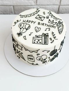 a birthday cake decorated with black and white doodles