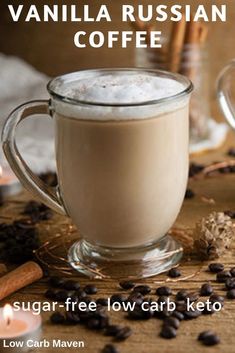 a cup of coffee sitting on top of a table next to cinnamons and candles