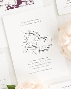 the wedding stationery is laid out on top of each other, with pink flowers