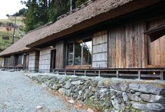 a row of wooden buildings sitting next to each other on top of a forest covered hillside