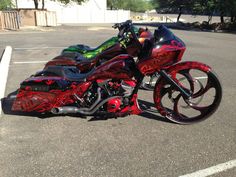 a red motorcycle parked in a parking lot next to another motorcyclist's bike