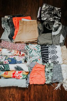 a pile of clothes sitting on top of a wooden floor