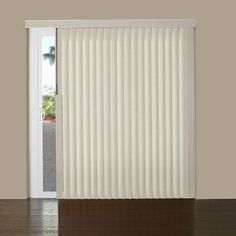 an open door with white vertical blinds on the outside, and wood floors in front