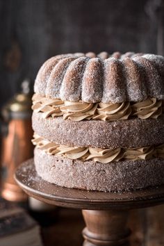 a cake sitting on top of a wooden table covered in powdered sugar and icing