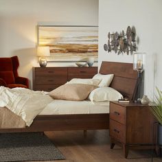 a bed sitting in a bedroom next to a night stand and dresser with two lamps on top of it