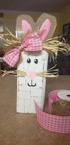 a wooden block with a pink bow on it and some burlocks around it