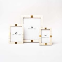 three white and gold frames sitting next to each other on top of a white surface