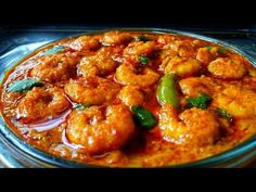 a bowl filled with shrimp and sauce on top of a stovetop burner oven