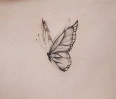 a black and white photo of a butterfly on the back of a woman's stomach