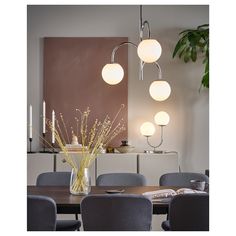 a dining room table surrounded by chairs and lights