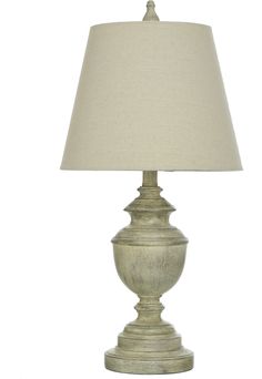 a white lamp with a beige shade on it's base and a light bulb in the middle