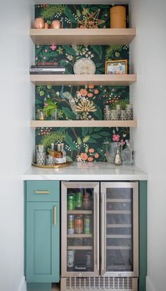 a kitchen with green cabinets and floral wallpaper