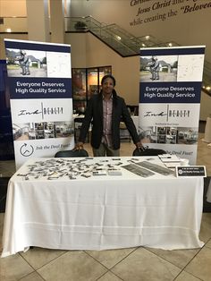 a man standing next to a table with signs on it