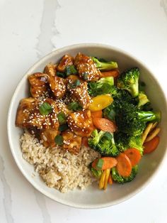 a white bowl filled with rice, broccoli and chicken on top of it