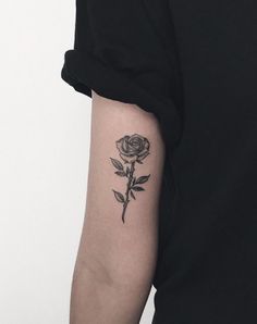 a black rose tattoo on the left arm