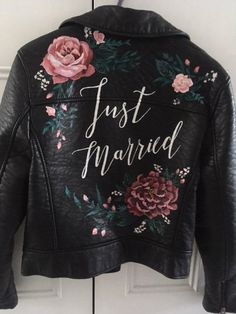 a black leather jacket with flowers painted on it and the words just married written in white