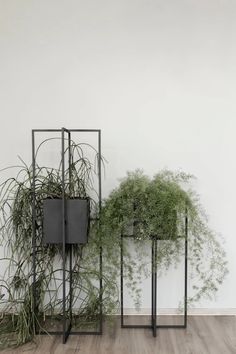 two metal plant stands with plants in them