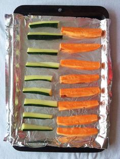 sliced up vegetables on aluminum foil sitting on top of a table