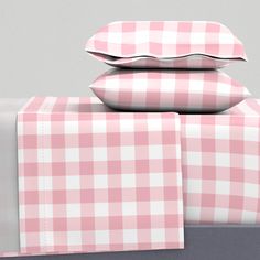 pink and white checkered bedding with matching pillowcases on top of each other