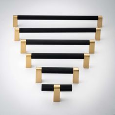 four black and gold handles on white wall