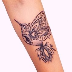 a black and white photo of a tattoo on the arm with an intricate bird design