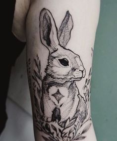 a black and white rabbit tattoo on the arm