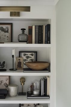 the shelves are filled with books and vases