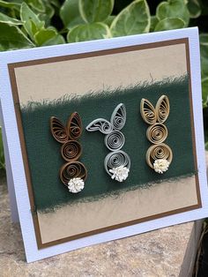 three different types of paper quilling on a card next to some flowers and leaves