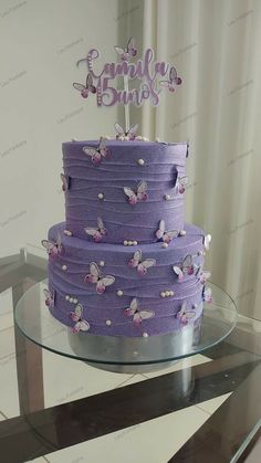 a three tiered purple cake with butterflies on it