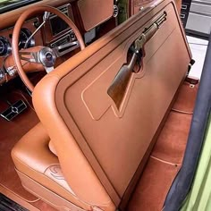 the interior of an old car with brown leather and wood trims, including steering wheel