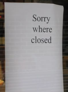 a sign that says sorry where closed in front of a store window with an orange slice on it