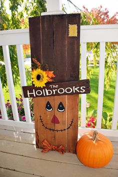 a wooden sign that says the holidays on it next to a pumpkin and sunflower