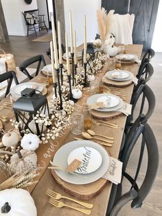 a table set for thanksgiving dinner with candles and place settings