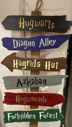 a wooden sign that says hogwarts, diagon alley, hagrids hut and forbidden forest