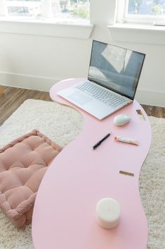 a pink desk with a laptop on it