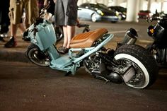 a scooter that is laying on the ground in front of some parked motorcycles