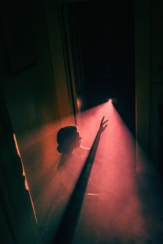 the shadow of a person's head is cast by a light coming from an open door