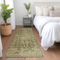 a bed with white sheets and pillows in a bedroom next to a green rug on the floor