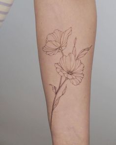 a woman's leg with a flower tattoo on the left side of her arm