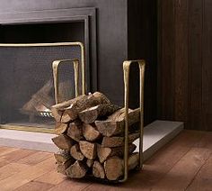 a stack of logs in front of a fireplace with a firewood holder on the floor