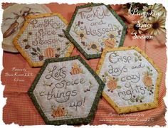 three embroidered coasters with words on them and pumpkins in the middle, one saying happy