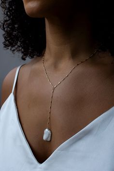 "A dainty Y-necklace with a large focal keshi pearl.  Dainty and unique, this wispy style gives a modern approach to a pearl necklace.  Lightweight and comfortable to wear.  Closure: spring ring Materials: 14K Gold Filled or Sterling Silver Measures approx. 18\" in length + 3 1/2\" drop Handmade in New York Arrives perfectly packaged, ready for gift-giving! Due to the nature of pearls, each pair will be slightly different, lending to a one of a kind design." White Lariat Pearl Necklace With Delicate Chain, Minimalist Gold Pearl Lariat Necklace, Long Drop Pearl Charm Necklace As Gift, Minimalist Gold Lariat Necklace With Pearls, Long Drop Pearl Charm Necklace For Gift, Dainty White Lariat Necklace With Pearl Charm, Gift Long Drop Pearl Charm Necklaces, Wedding Jewelry With Delicate Chain And Baroque Pearl, Wedding Baroque Pearl Jewelry With Delicate Chain