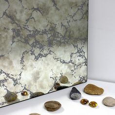 some rocks are on the ground in front of a mirror