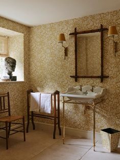 a bathroom with a sink, mirror and chair in the corner next to a window